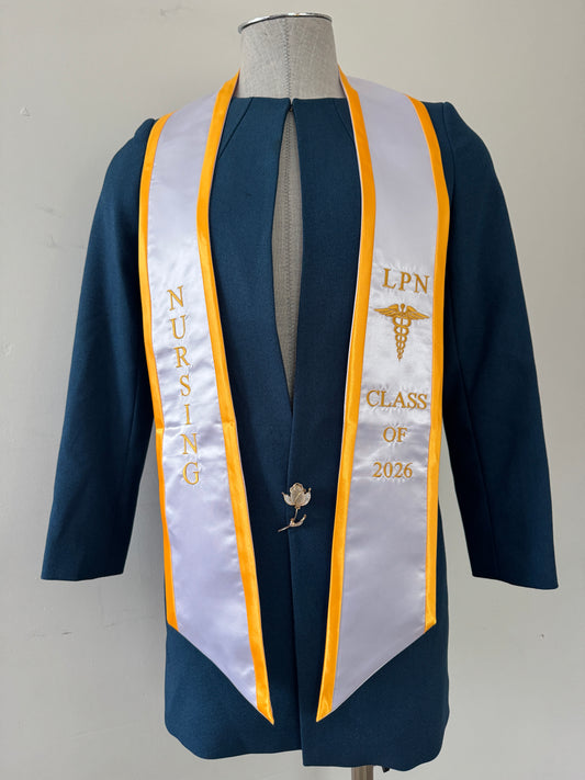 A White With Gold Trim LPN graduation stole with royal blue trim, showcasing bold 'LPN ' lettering embroidered at the top, followed by a medical logo and 'CLASS OF 2026' embroidered beneath. The stole has slanted tips and a white plain background. All characters are embroidered.